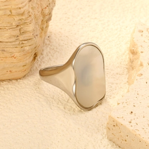 Detailed view of silver signet ring with irregular shape on organic stone background