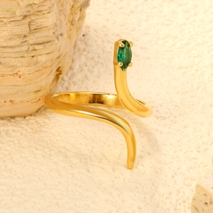 Polished gold snake ring with green marquise zircon set on a textured natural stone background