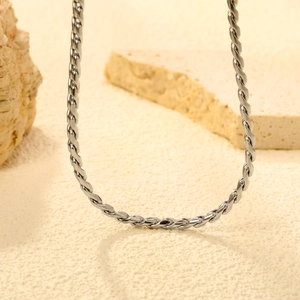 Gros plan d'une chaîne torsadée en acier inoxydable plaqué or 18 carats