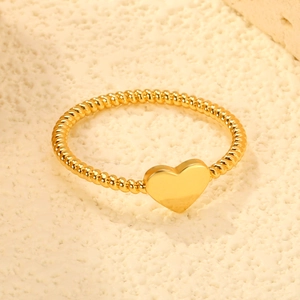 Minimalist gold heart open ring with twisted rope band on stone background