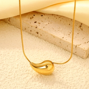 Macro view of 18K gold plated teardrop pendant on a sleek snake chain necklace