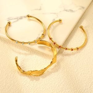 Three-piece gold plated stainless steel open bangle set with evil eye charms and wave texture