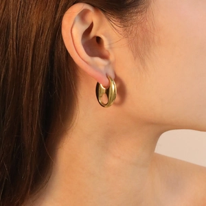 Boucles d'oreilles ovales épaisses en acier plaqué or 18K portées par un mannequin