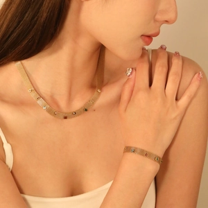 Parure de bijoux en maille dorée avec strass colorés incluant un collier et un bracelet