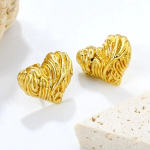 Textured gold heart stud earrings with lava metal surface on minimalist stone base