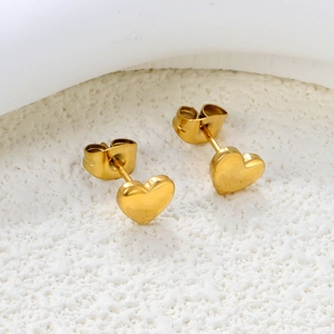 Detail of polished gold heart stud earrings with secure butterfly backings