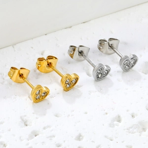 Elegante goldene und silberne Herzohrstecker mit Zirkonia-Inlay auf Marmoroberfläche