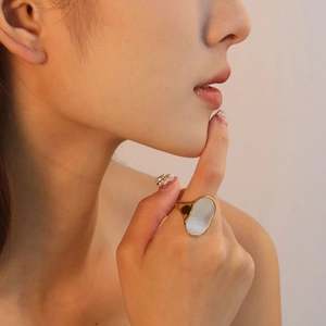 Irregular white shell ring in 18K gold plated stainless steel on female model hand