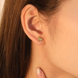 Polished 18K gold plated stainless steel heart stud earrings worn by a model