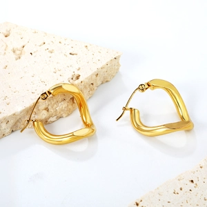 Boucles d'oreilles cœur dorées luxe français sur support en pierre minimaliste