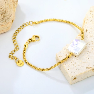 Gold beaded stainless steel bracelet featuring a rectangular pearl on a stone pedestal