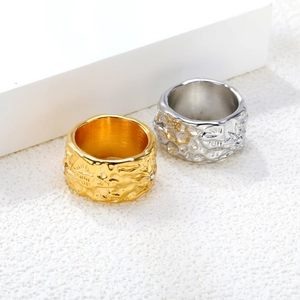 Set aus Gold- und Silber-Edelstahlringen mit Lava-Textur auf weißem Präsentationsständer