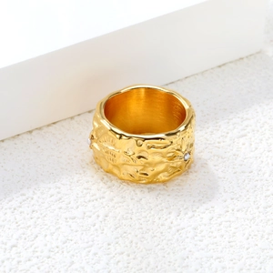 Makroaufnahme von breitem Edelstahlring in Gold mit Hammerschlag-Textur und Perlen