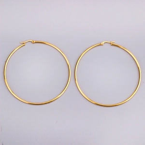 Detail of 2mm gold stainless steel hoop earrings featuring a high-polish mirror finish