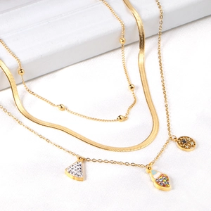 Dettaglio della collana dorata a più strati stile oceano con ciondoli in strass e stelle