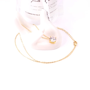 Detailed view of a gold chain necklace with a sparkling round zircon pendant on a display