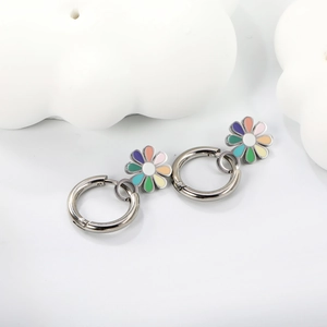 Détail de boucles d'oreilles marguerites colorées avec créoles argentées sur fond blanc