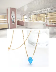 Detail of star-shaped blue opal pendant on a thin gold chain stainless steel necklace