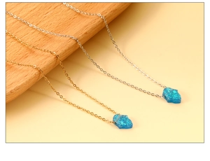 Macro detail of blue Hamsa opal pendants in gold and silver stainless steel chains