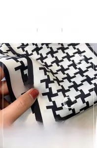 Detail showing high-quality silk-like texture and classic houndstooth pattern of the scarf