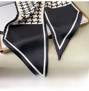 Detail of silk scarf showing black and white houndstooth pattern and refined stitching
