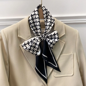 Fashionable houndstooth neck scarf tied in a bow on a beige blazer collar for work