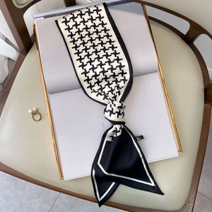 Elegant black and white houndstooth silk scarf tied on a magazine with pearl ring decor