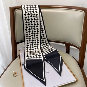 Detail of black and white houndstooth twilly scarf draped over a wooden chair