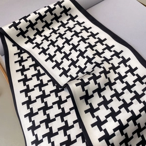Close-up of geometric cross pattern on narrow black and white silk neck scarf twilly