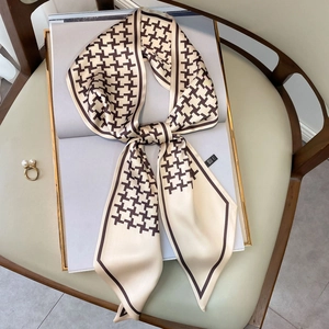 Elegant cream and brown houndstooth silk scarf on a magazine and leather chair