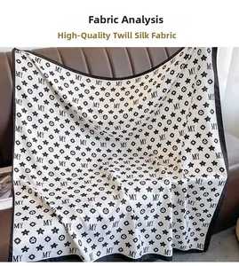 Détail d'un foulard en soie blanche avec lettres MY noires et motifs floraux