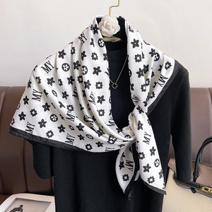 Foulard en soie pied-de-poule classique avec monogramme drapé sur un pull noir