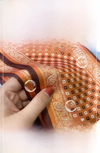 Detailaufnahme des glatten orangen Seidentuchs mit feinen Paisleymustern und Glanz