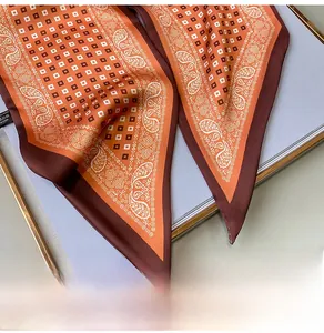 Detail eines Seidenschals mit Paisley-Muster, orangefarbenem Design und feinen Nähten
