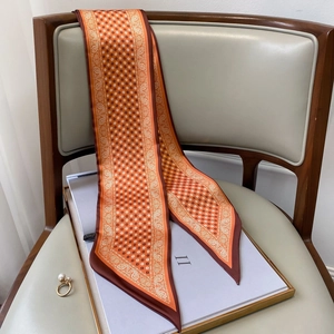 Nahaufnahme eines geometrischen orangefarbenen Seidenschals mit Paisley-Muster
