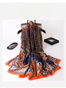 Detailed close-up of silk scarf with vintage floral patterns and orange border hem