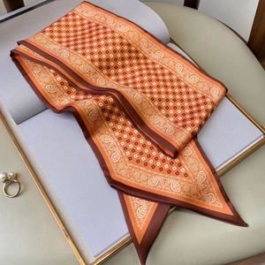 Detail eines orange-braunen Twilly-Schals mit Paisley-Muster und Satin-Glanz