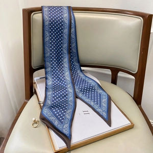 Detailaufnahme des dunkelblau-braunen Twilly-Seidenschals mit Paisley-Muster auf Stuhl