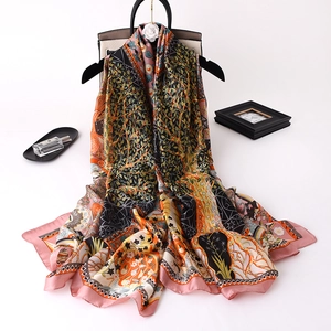 Elegant satin silk shawl with warm floral prints hanging on a black rack with accessories