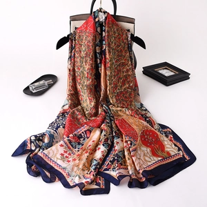 Artistic silk satin scarf with colorful floral and tree prints on a black hanger