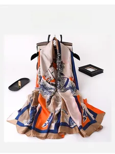 Close-up of silk-feel scarf with equestrian horse print and vibrant orange borders