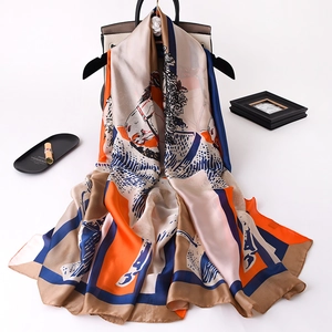 Detail of silk scarf with equestrian horse print draped over a luxury handbag handle