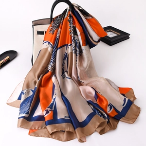Close-up of luxury silk scarf featuring artistic abstract print draped over a stylish handbag