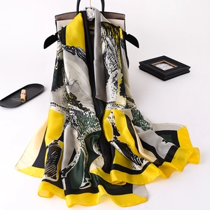 Close-up of a satin silk scarf with equestrian horse print draped over a luxury handbag