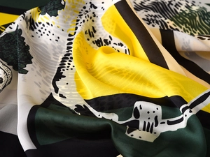 Detail of silk-like scarf showing luxury drape and modern geometric tropical pattern