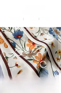 Detalle de bufanda de seda floral que muestra costuras finas y textura suave