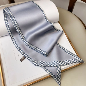 Detailed view of Morandi blue narrow silk-feel scarf with classic houndstooth trim pattern