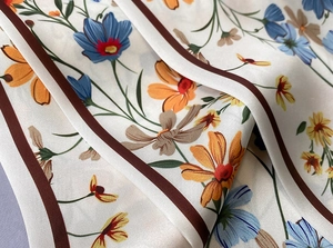Primer plano de bufanda de seda estampada con textura suave y diseño de flores de margarita