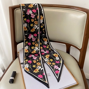 Detalle de pañuelo estrecho de seda con estampado floral sobre una silla vintage elegante