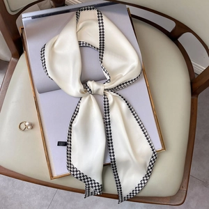 Elegant houndstooth silk scarf in cream white shown in a stylish fashion setting